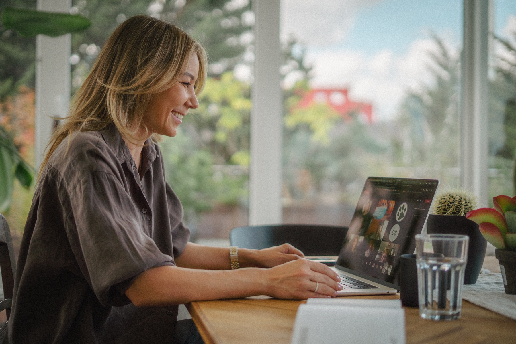 Julia Li lächelt bei der Arbeit am Laptop